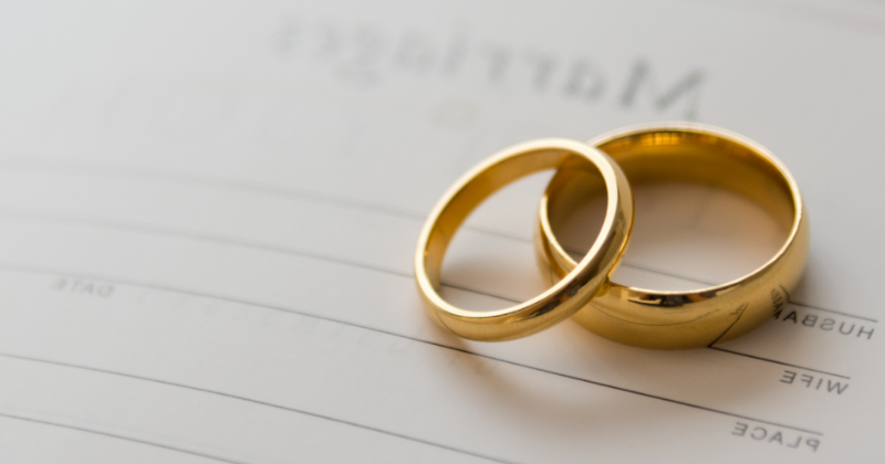 Two gold rings on a marriage certificate.